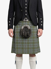 Person wearing a traditional Scottish kilt with a sporran on a white background