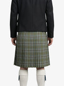 Person wearing a black jacket and green plaid kilt on a white background