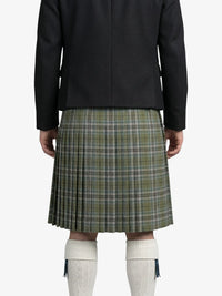Person wearing a black jacket and green plaid kilt on a white background