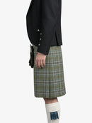 Person wearing a black jacket and green plaid kilt on a white background