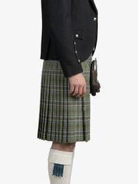 Person wearing a black jacket and green plaid kilt on a white background