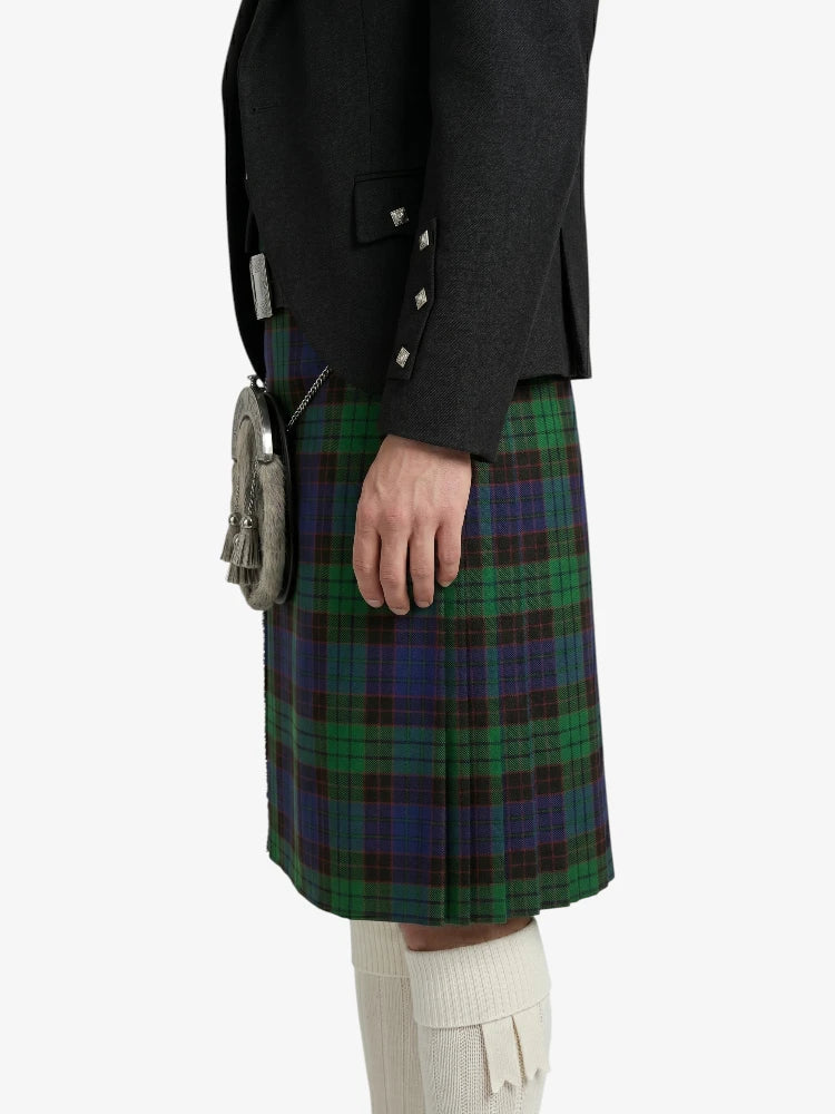 Person wearing a dark coat and green plaid kilt on a white background
