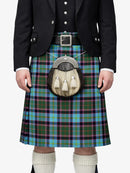 Person wearing a traditional Scottish kilt with a tartan pattern on a white background