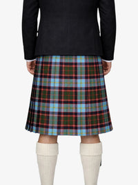 Person wearing a black jacket and plaid kilt on a white background