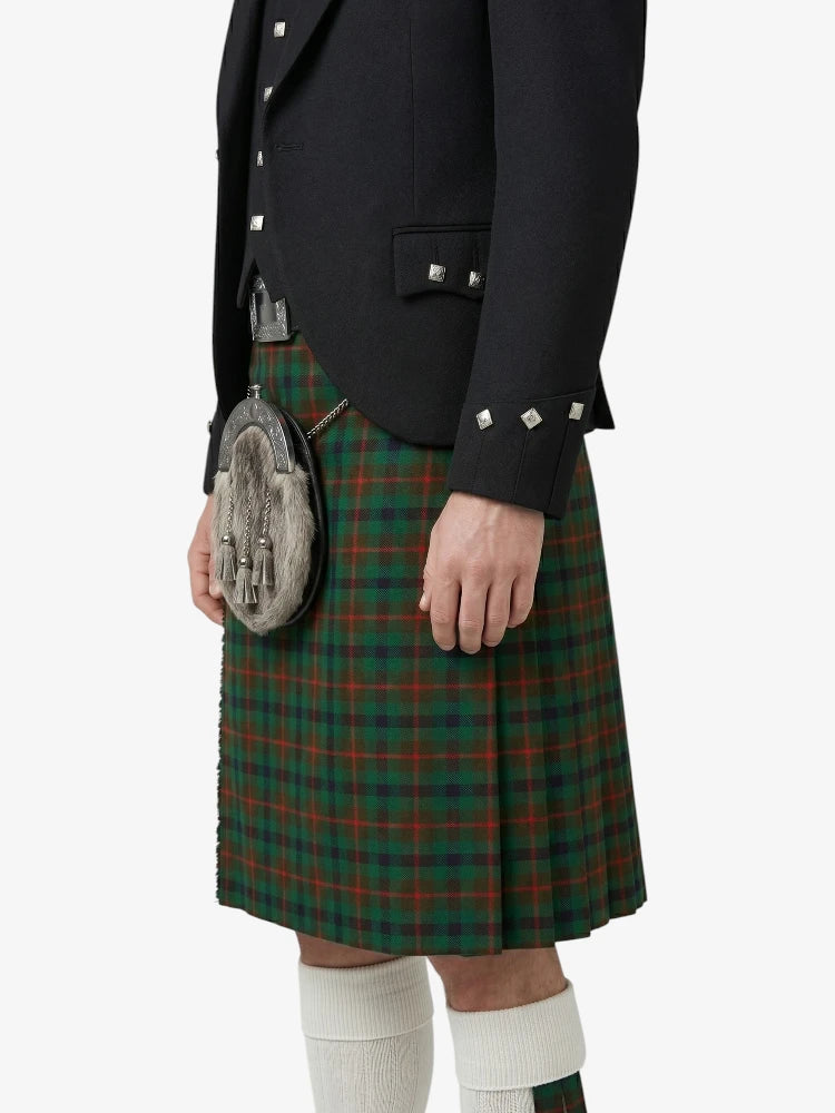 Person wearing a traditional Scottish kilt with a jacket on a white background