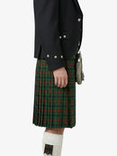 Person wearing a dark jacket and green plaid kilt on a white background
