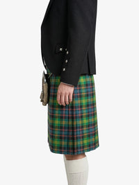 Person wearing a black jacket and green plaid kilt on a white background