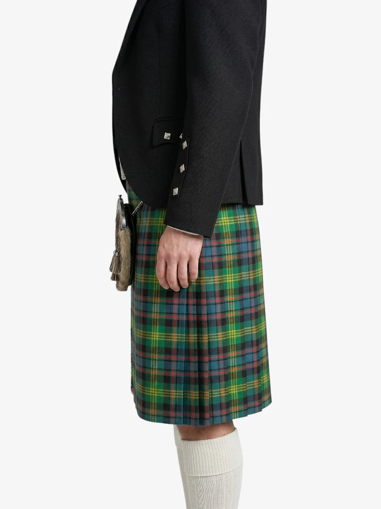 Person wearing a black jacket and green plaid kilt on a white background