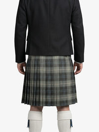 Person wearing a black jacket and plaid kilt on a white background