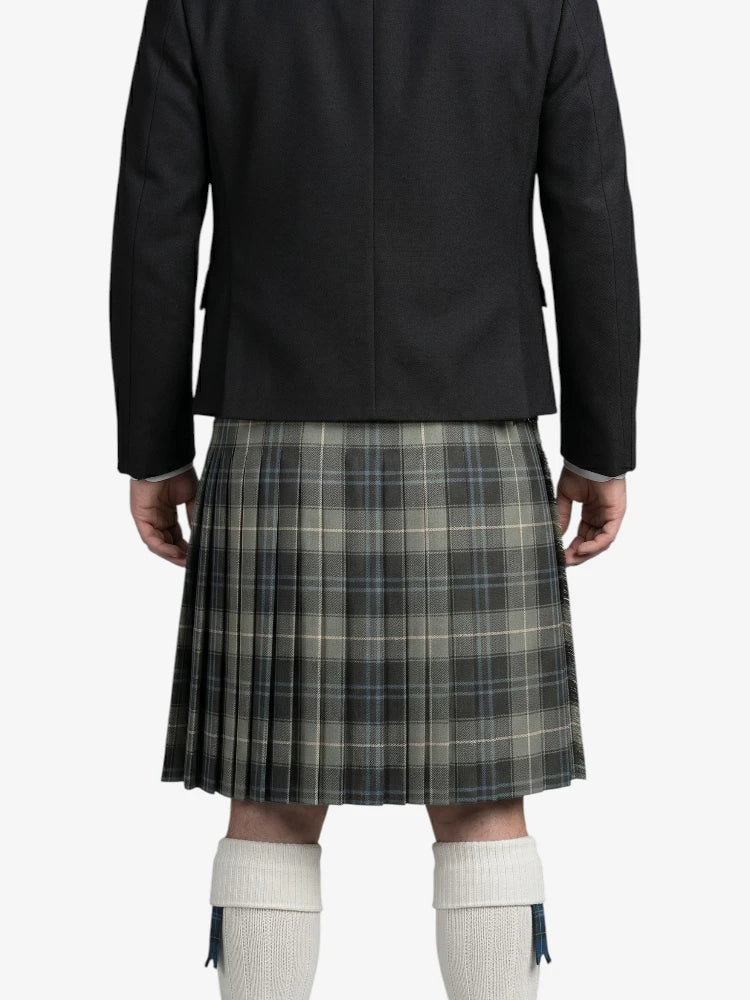 Person wearing a black jacket and plaid kilt on a white background