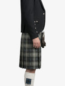 Person wearing a black jacket and plaid kilt on a white background