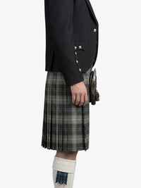 Person wearing a black jacket and plaid kilt on a white background