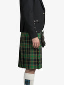 Person wearing a black jacket and green plaid kilt on a white background