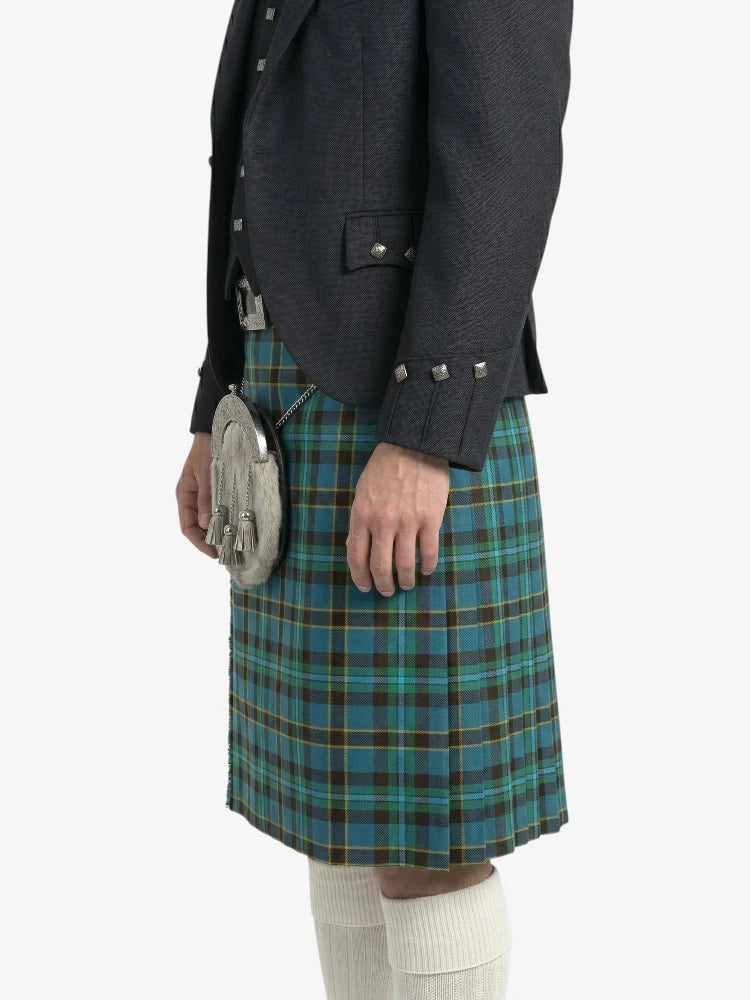 Person wearing a dark jacket and blue plaid kilt on a white background