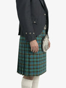 Person wearing a dark jacket and blue plaid kilt on a white background
