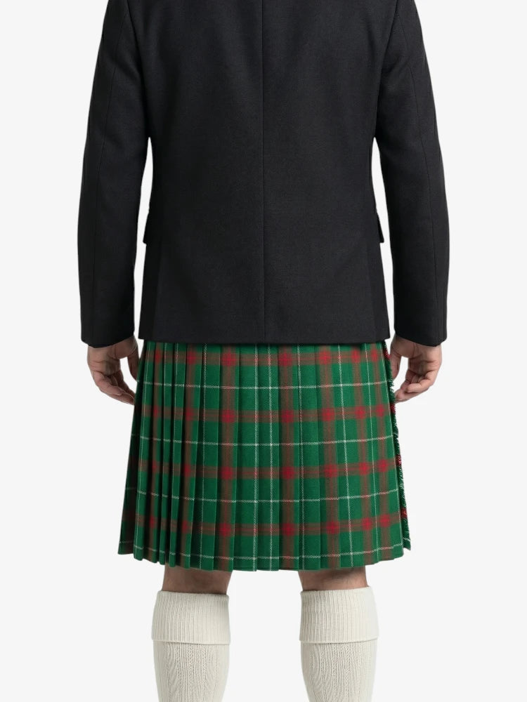 Person wearing a black coat and green plaid kilt on a white background