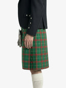 Person wearing a green plaid kilt with a dark jacket on a white background
