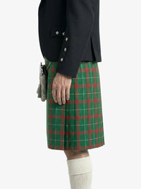 Person wearing a green plaid kilt with a dark jacket on a white background