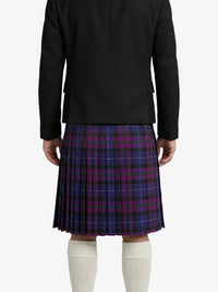 Person wearing a black jacket and purple plaid kilt on a white background