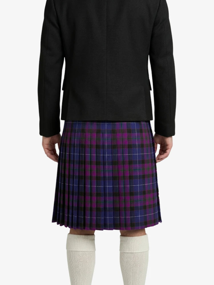Person wearing a black jacket and purple plaid kilt on a white background