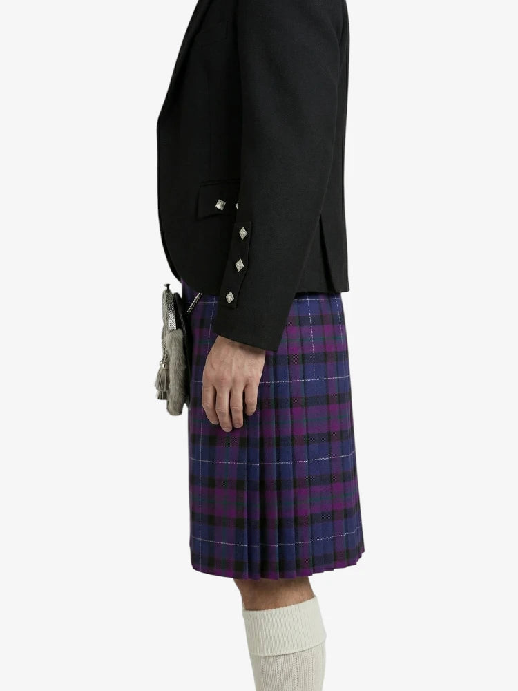 Person wearing a black jacket and purple plaid kilt on a white background
