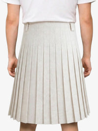 Beige pleated skirt worn by a person on a white background