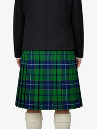 Person wearing a green and blue plaid kilt with a black jacket on a white background